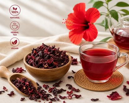 Hibiscus tea with dried hibiscus flowers, a cup of tea, and a red flower on a light background.