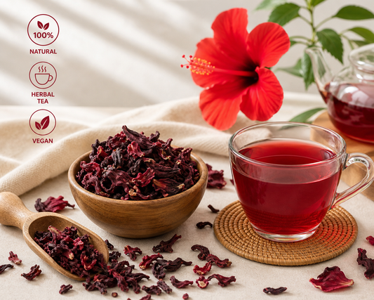 Hibiscus tea with dried hibiscus flowers, a cup of tea, and a red flower on a light background.